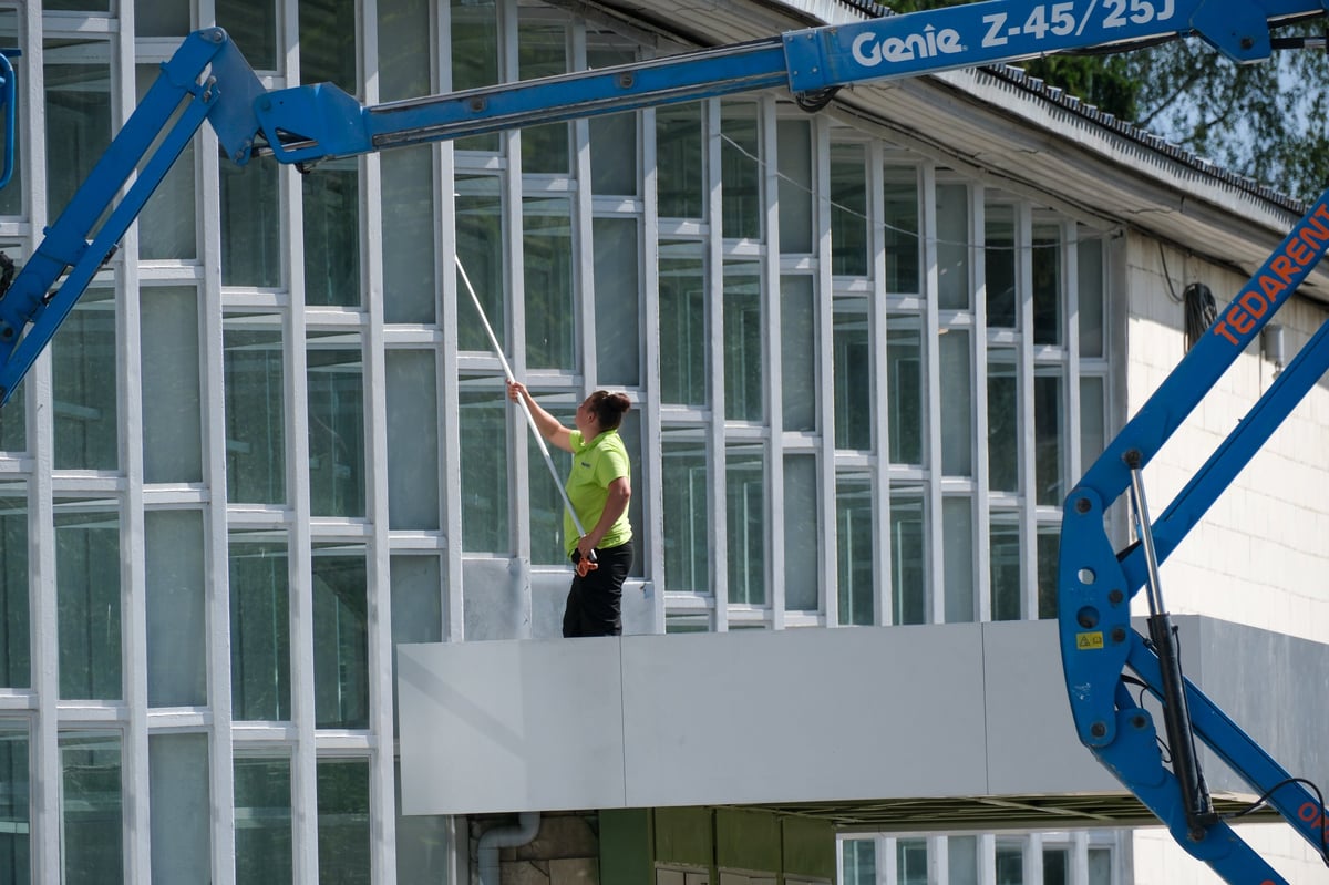 Professional worker cleans the glass facade of a modern building